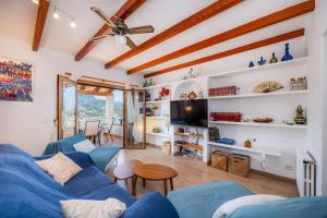 a living room with a blue couch and a tv at Sa Torreta Luxury Views 3 Bedrooms in Sóller