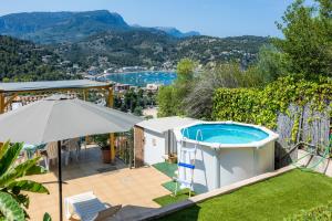 a villa with a swimming pool and an umbrella at Sa Torreta Luxury Views 3 Bedrooms in Sóller