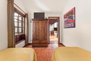 a bedroom with two beds and a door with a window at Villasal in Playa Blanca