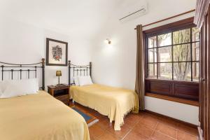 two beds in a room with a window at Villasal in Playa Blanca