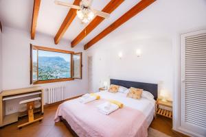 a bedroom with two beds and a tv and a window at Sa Torreta Luxury Views 3 Bedrooms in Sóller +26 photos