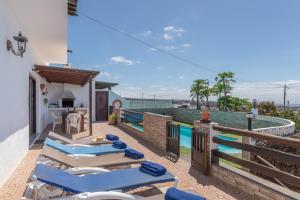 a balcony with lounge chairs and a swimming pool at Andres House, Tías in Tías