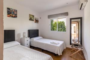 a bedroom with two beds and a mirror and a window at Oleanda in Alcudia +18 photos