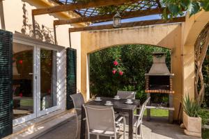a patio with a table and chairs and a large window at Oleanda in Alcudia