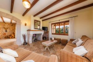 a living room with two couches and a fireplace at Turó de na Roca in S'Horta