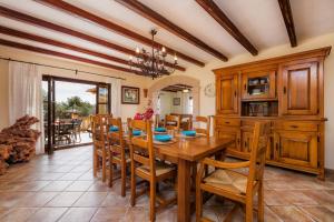 a kitchen and dining room with a wooden table and chairs at Turó de na Roca in S'Horta