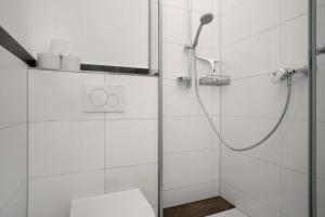 a white bathroom with a shower and a toilet at Thaicenter Bodensee 2 in Friedrichshafen +18 photos