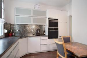 a kitchen with white cabinets and a wooden table at Thaicenter Bodensee 2 in Friedrichshafen