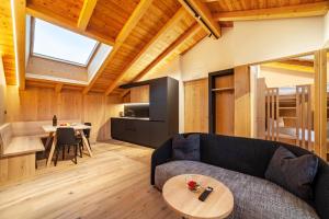 a living room with a couch and a table at Huetterhof Apartement Herbischt in Caines