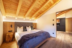 a bedroom with a large bed and a wooden ceiling at Huetterhof Apartement Herbischt in Caines