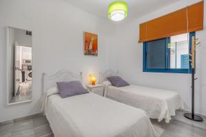 two beds in a room with white walls at Piso Castell in Castell de Ferro +21 photos