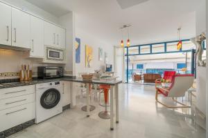 a kitchen with white cabinets and a table and chairs at Piso Castell in Castell de Ferro