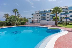 a large swimming pool in front of a building at Piso Castell in Castell de Ferro