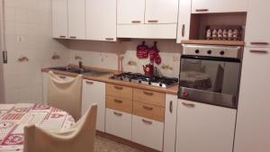 a kitchen with white cabinets and a stove top oven at Mansarda le Chateau in Aymavilles +16 photos