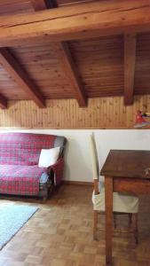 a bedroom with a bed and a desk and a table at Mansarda le Chateau in Aymavilles