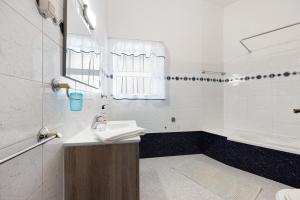 a white bathroom with a sink and a tub at Apartment T2 Malveiro in Odeceixe