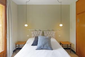 a bedroom with a white bed with two tables at El Campanar in Sant Llorenç de Morunys