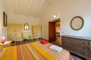 a bedroom with a bed and a dresser and a mirror at Casa vacanza Macciunitta in Arzachena