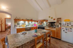 a kitchen with a table and a refrigerator at Casa vacanza Macciunitta in Arzachena