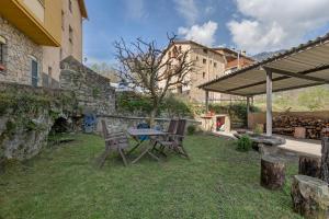 a picnic table and two chairs in a yard at El Campanar in Sant Llorenç de Morunys