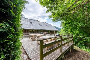 a wooden deck with picnic tables in front of a building at Les Chalets de la Revue in Flumet