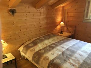 a bedroom with a bed in a log cabin at Chalet La Grangette in Abondance