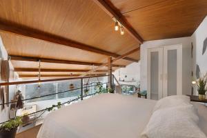 a bedroom with a white bed and a balcony at Casa Tajaraste 2 in Hermigua