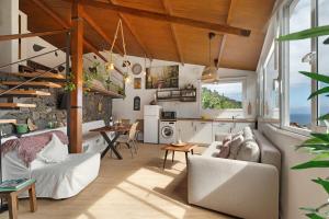 a living room with white furniture and a kitchen at Casa Tajaraste 2 in Hermigua