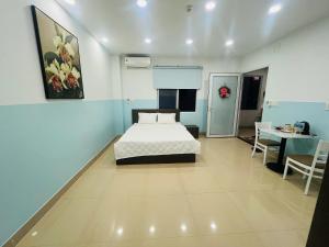 a bedroom with a bed and a table and a desk at Homestay 150 in Ho Chi Minh City