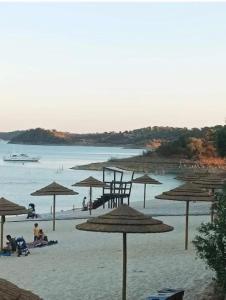 a beach with umbrellas and people on the sand at Casa Do Mestre Lau in Terena