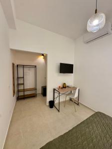 a room with a table and a white wall at Trapani Urban Nest in Trapani