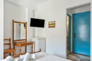 a room with a bed and a tv on the wall at Hotel Galini in Kalymnos