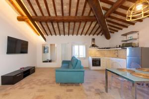 a living room with a blue chair and a table at Borgo Ariano near Volterra by PosarelliVillas in Volterra