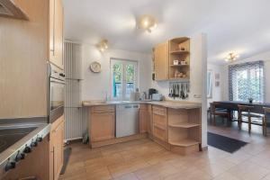 a kitchen with wooden cabinets and a dining room at Ferienhaus alte Münze in Neuerburg