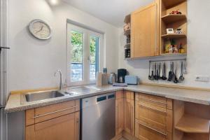 a kitchen with a sink and a clock on the wall at Ferienhaus alte Münze in Neuerburg