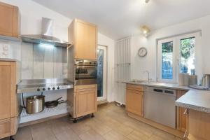 a kitchen with stainless steel appliances and wooden cabinets at Ferienhaus alte Münze in Neuerburg