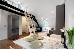 a kitchen and living room with a dining table and a staircase at Adlernest mit Weinbergblick in Trittenheim