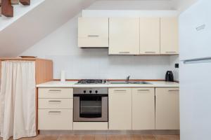 a kitchen with white cabinets and a stove top oven at Villetta Confortevole in San Teodoro