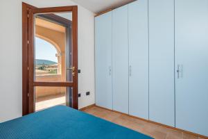 a bedroom with a bed and a glass door at Villetta Confortevole in San Teodoro