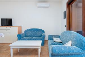 a living room with two blue chairs and a coffee table at Villetta Confortevole in San Teodoro