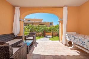 an outdoor patio with an archway and a table and chairs at Villetta Confortevole in San Teodoro