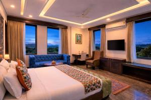 a hotel room with a bed and a television at The Colonial - A Lake View Hotel in Udaipur in Udaipur