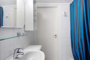 a bathroom with a sink and a blue shower curtain at Gästehaus Roth in Willingen +20 photos
