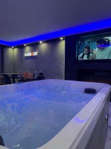 a large tub filled with water in a restaurant at Suite cinéma et jacuzzi privé in Melun