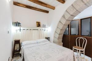 a bedroom with a bed and a chair in it at Ai Cannola - Calatafimi Segesta in Calatafimi