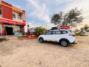 a white car parked in front of a building at Ligree Hotel and Restaurant in Jatwāra
