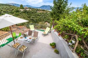 a patio with a table and chairs and an umbrella at Scorpios View Meganisi in Meganisi