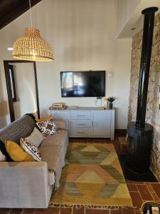 a living room with a couch and a flat screen tv at Villa Laguna - Charmy Villa in Moncarapacho