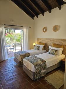 a bedroom with two beds and a patio at Villa Laguna - Charmy Villa in Moncarapacho +22 photos