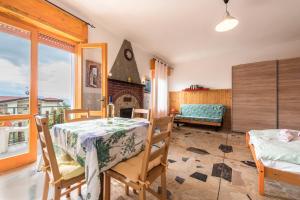 a room with a table and chairs and a fireplace at App Olivo Casa Demonti in Tignale